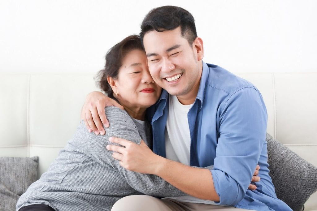 a grandmother hugs her grandson with smile. Happiness in old age