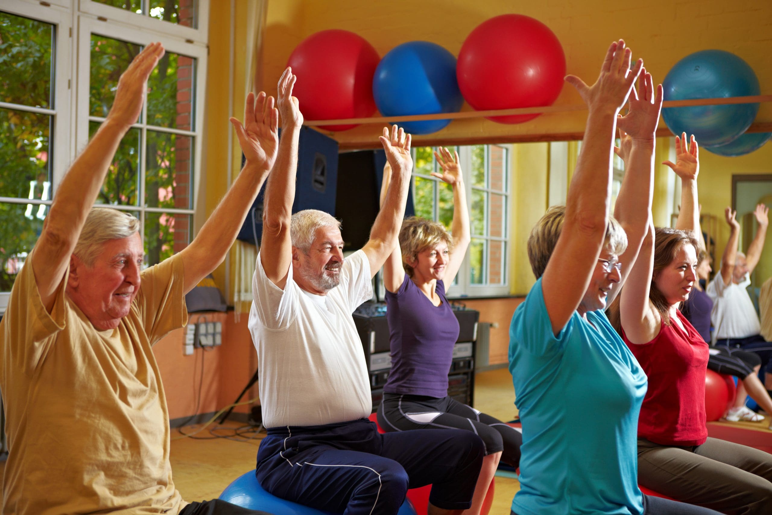 A group of seniors are playing sport like Pilates