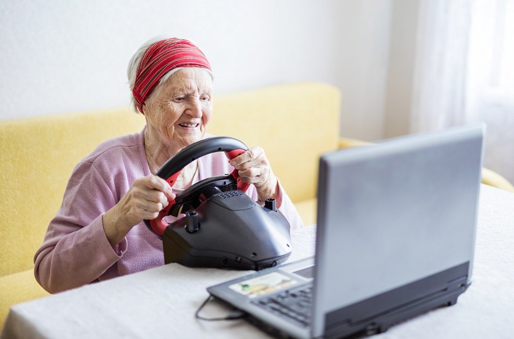 an old woman is playing Racing game with her laptop