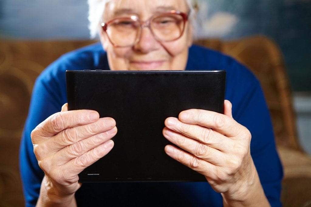 Senior woman is video calling with her tablet.