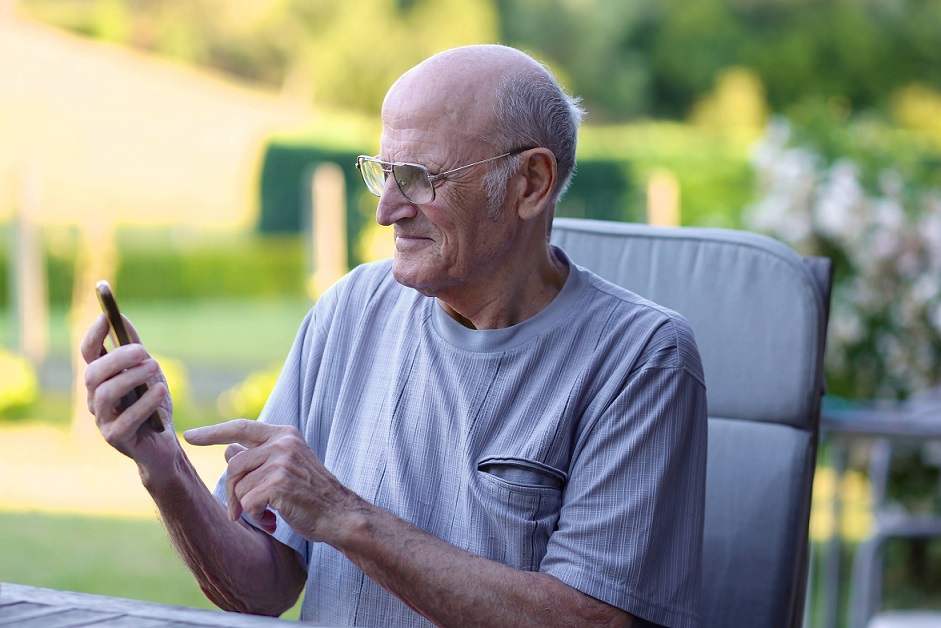 Senior Man is playing with her smartphone.