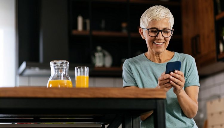 Senior woman checking her smartphone and smiles.