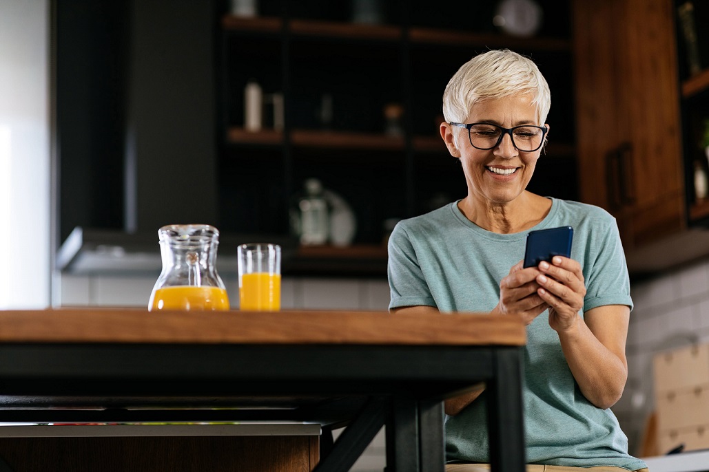 Senior woman checking her smartphone and smiles.