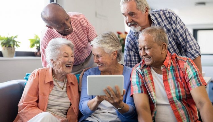 A group of seniors together are playing games in a Tablet. Seniors Using Technology.