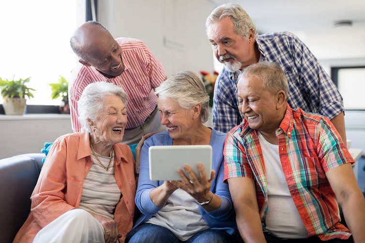 A group of seniors together are playing games in a Tablet. Seniors Using Technology.