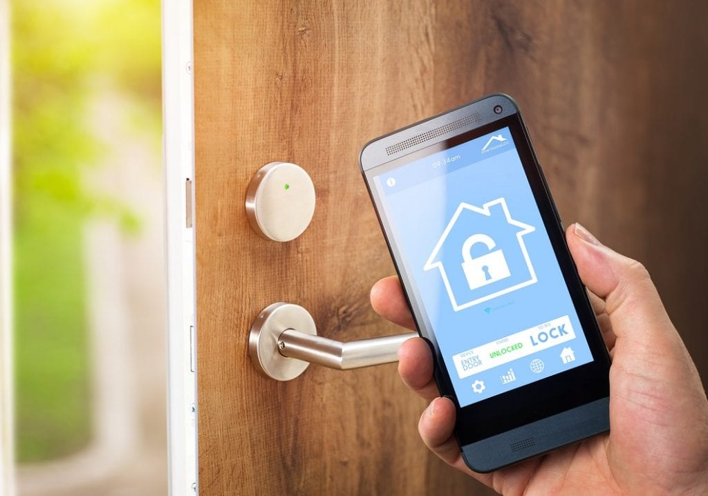 Senior Man uses his smartphone with smarthome security app to unlock the door of his house.