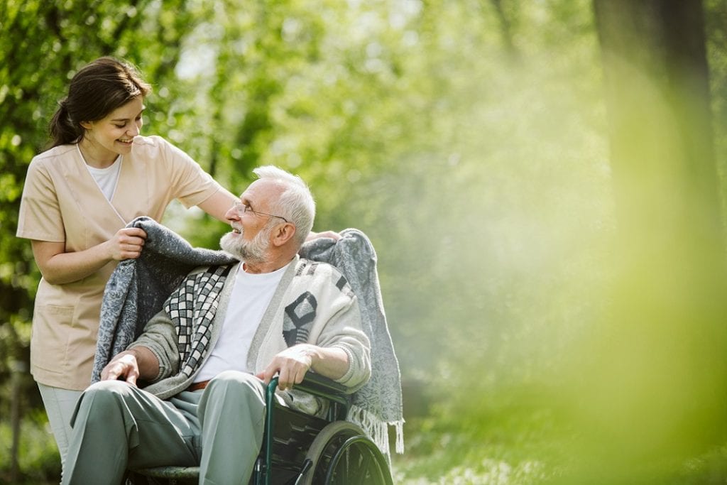 Caregiver wheeling a senior on wheelchair
