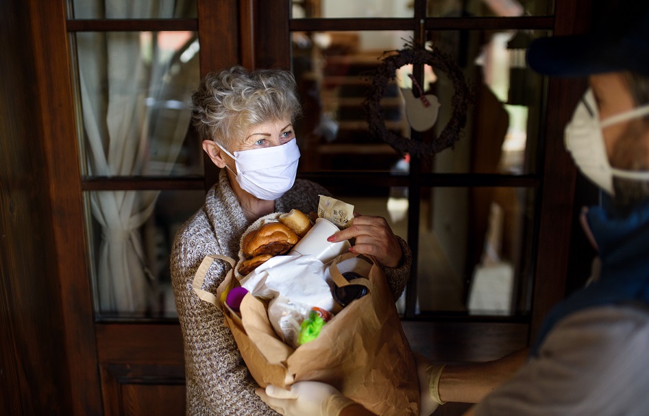 delivering shopping to senior woman with face mask, corona virus and quarantine.
