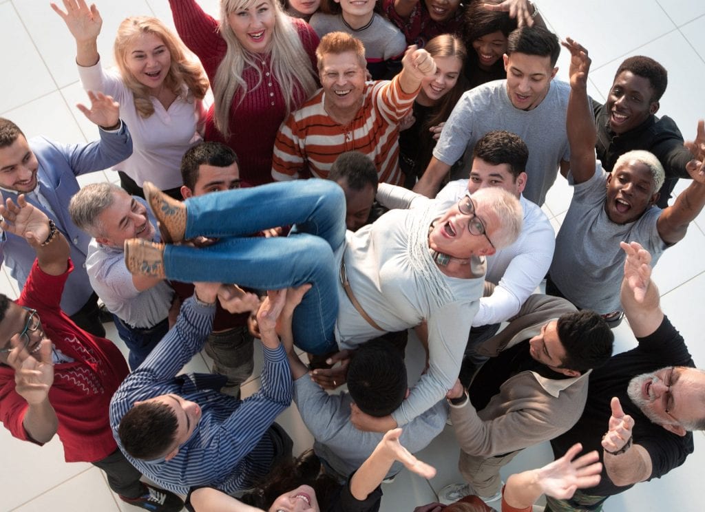 a group of people congratulating an elderly woman