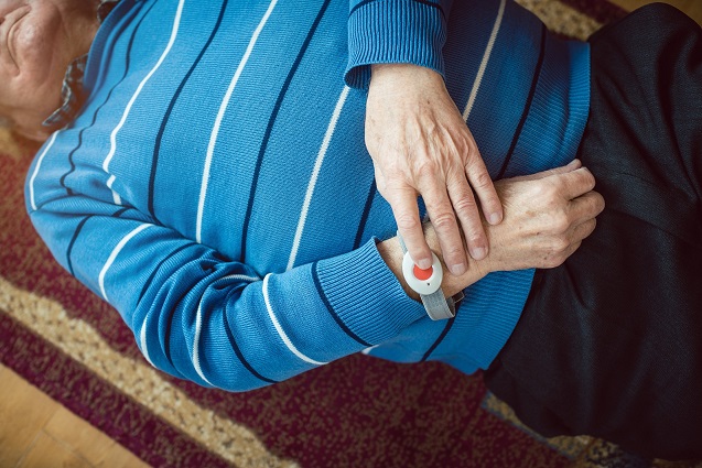 A senior using emergency button while falling