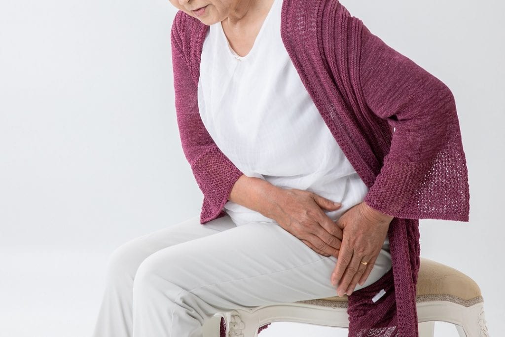 a senior woman with a problem in her hip joint due to exercising