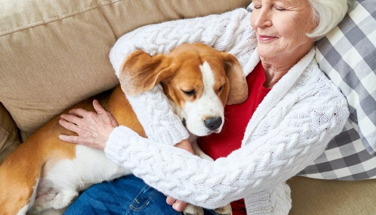 A senior woman hugging a dog