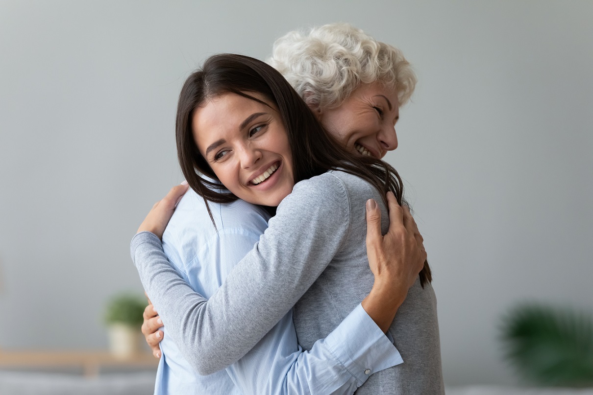 a young woman is hugging a senior woman