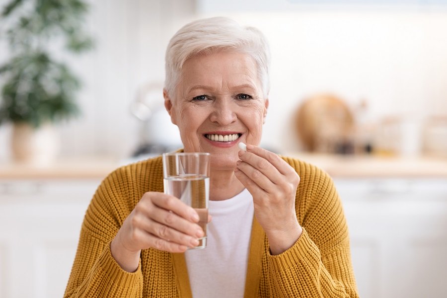 A senior woman taking vitamin supplements