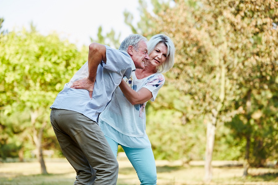 a senior woman helping her husband who has osteoporosis