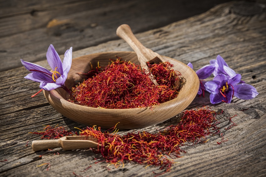 some saffron on a wooden table and two saffron blooms