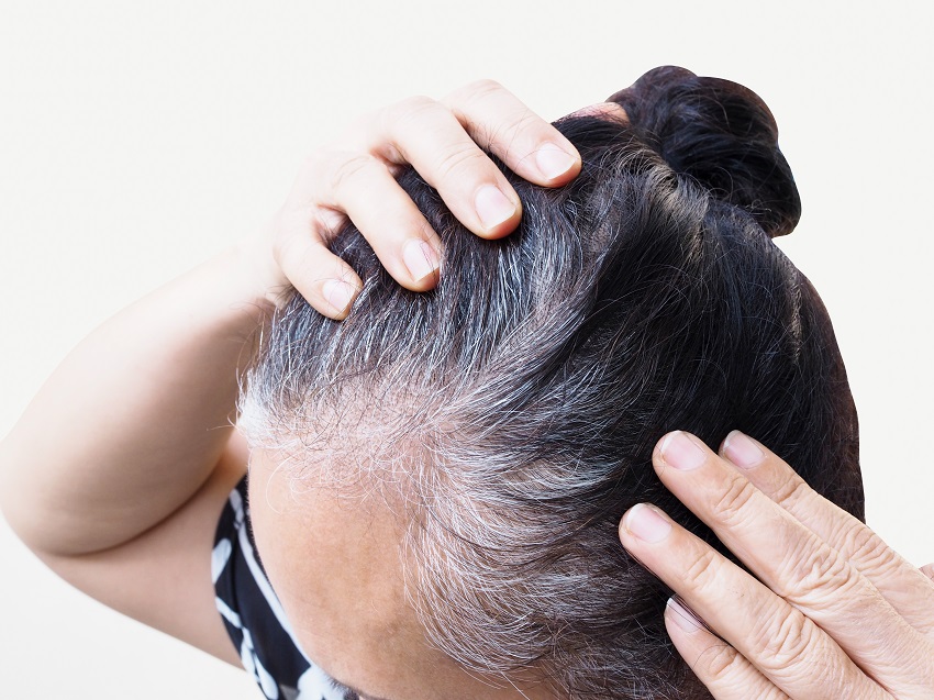 senior woman checking her hair for dandruffs