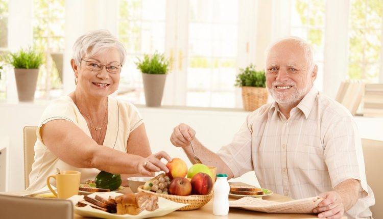 Senior couple eating breakfast at a table