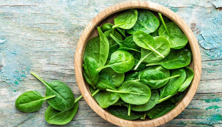 spinach leaves inside a wooden bowl