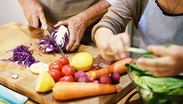 a senior couple making food in the kitchen