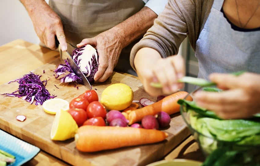 a senior couple making food in the kitchen