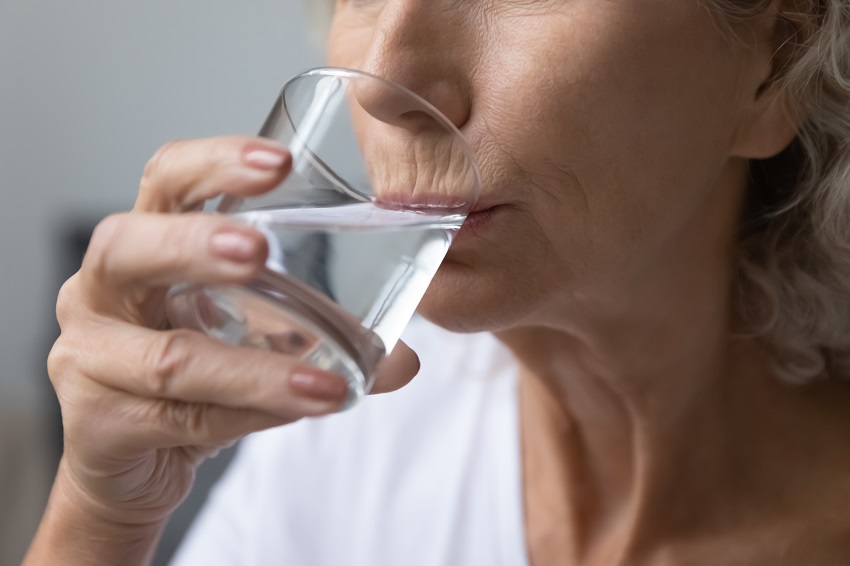 a senior woman drinking a glass of water