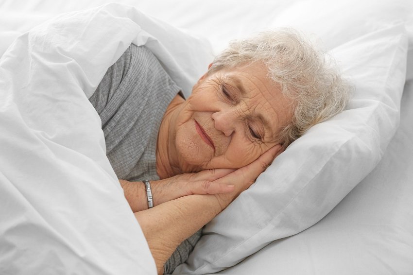 a senior woman sleeping on a bed