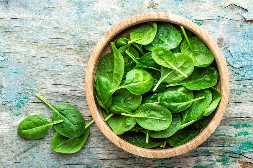 spinach leaves inside a wooden bowl
