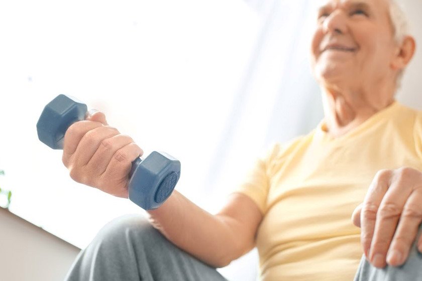 Senior exercising with a dumbbell, dumbbell workout for 60 year old man