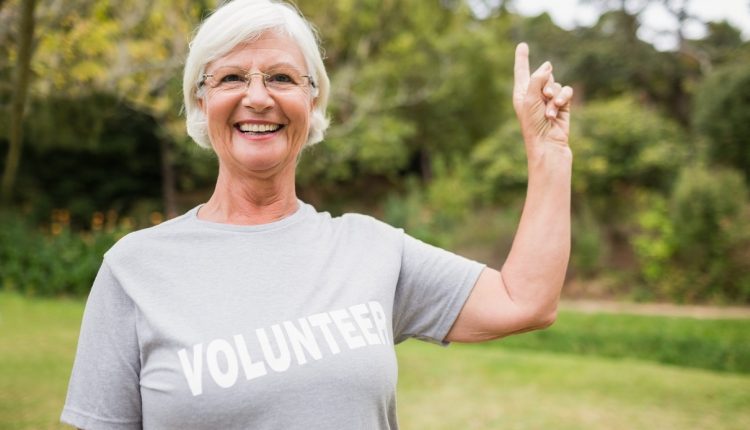 a senior woman with a t shirt with volunteer tag on it