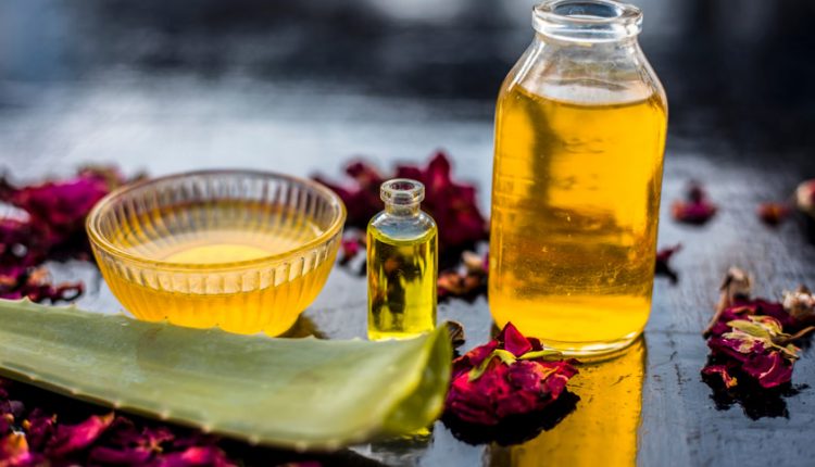 Some Aloe Vera gel with dried flowers and Aloe leaves on a wooden surface