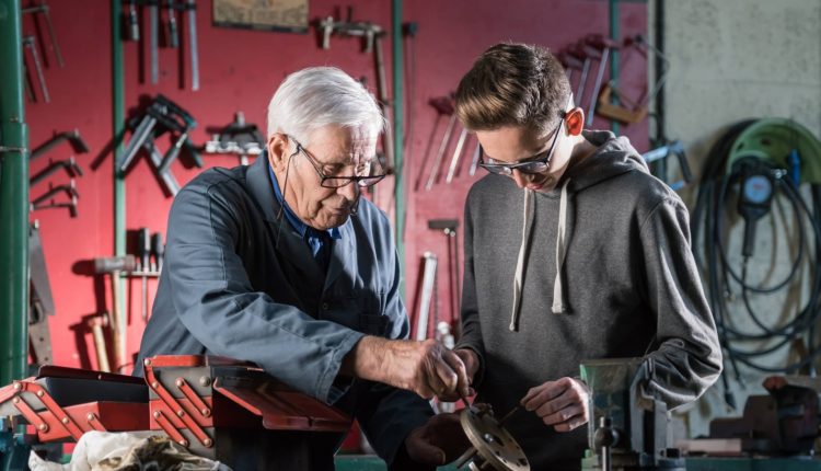 Senior and his grandchild working with metal in a garage