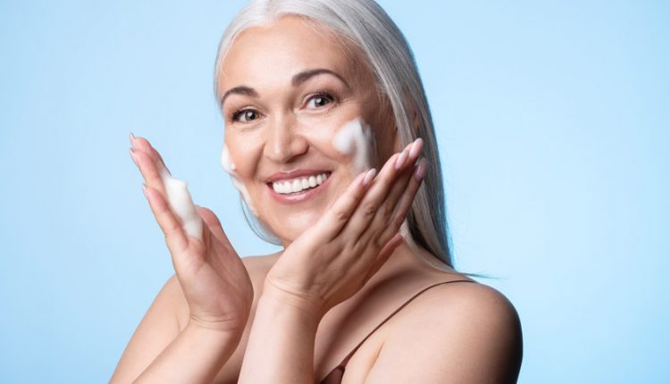 Attractive senior woman using a facial cleanser