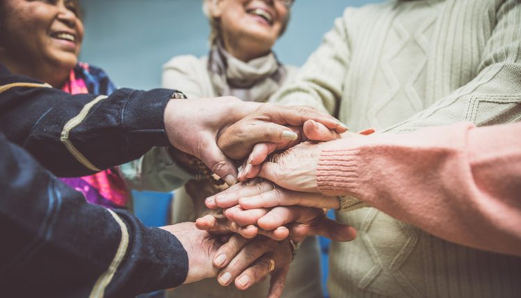 a group of seniors holding hands and smiling