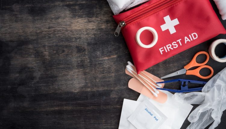 A first aid kit with scissors, band aids, Nylon gloves, and gauze swab for living alone seniors