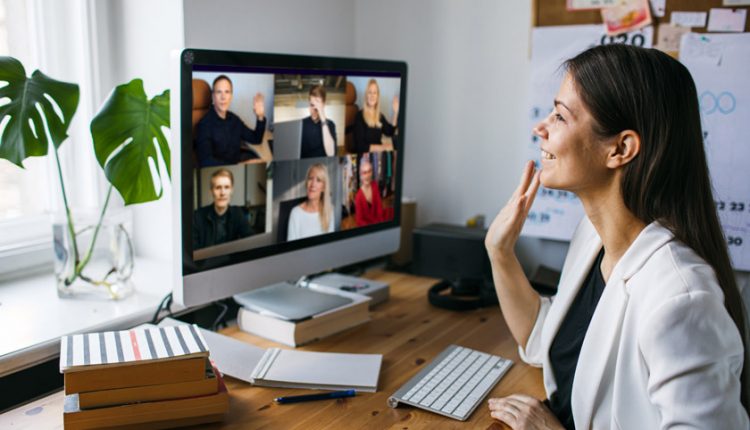 Young woman sitting behind her desk and being present in an online book club