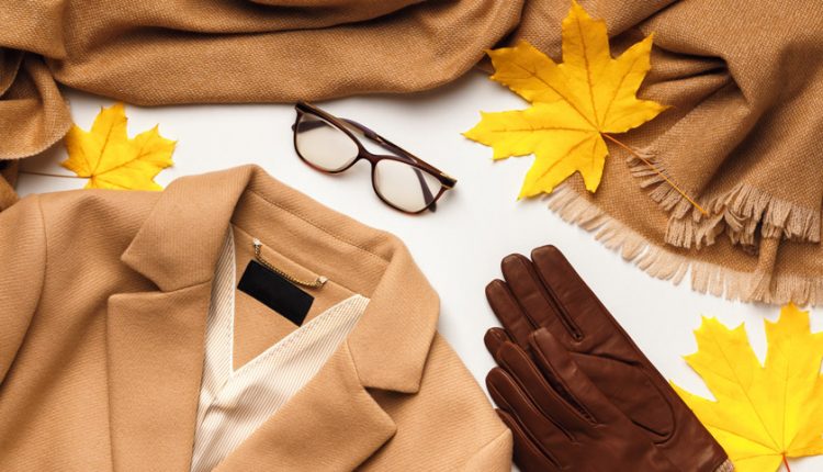 Warm winter brown coat, scarf, glasses, gloves with yellow maple leaves