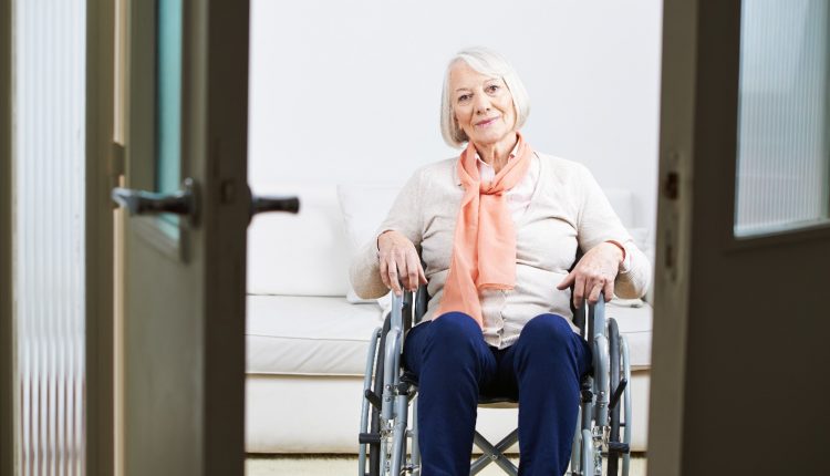 A senior woman sitting on a wheelchair, living alone elderly