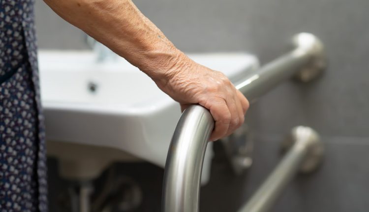 Hand of a female senior holding on to a grab bar in a senior-friendly bathroom