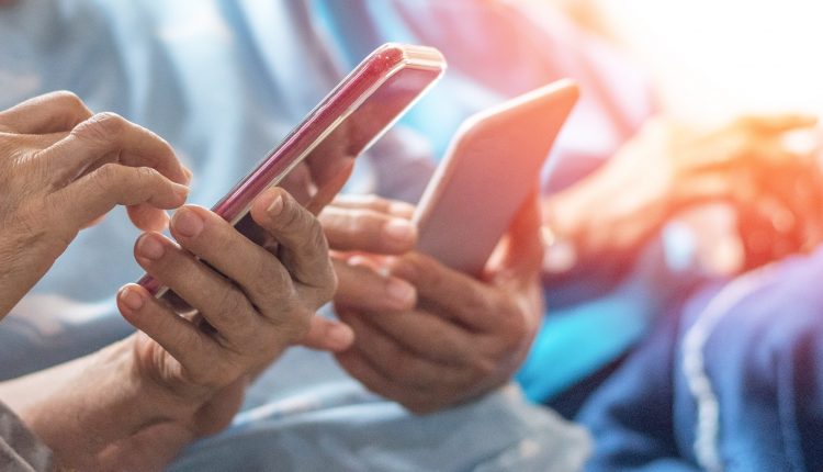 Some hands holding phones.