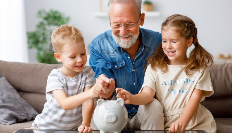 A grandfather helping his two grandchildren save money