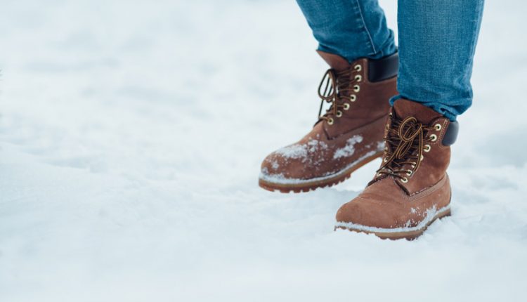 Brown men's warm winter boots on snow
