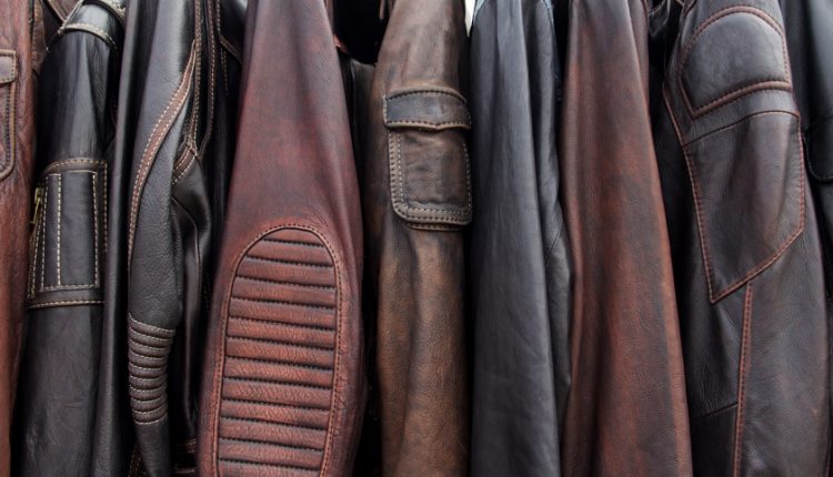Many men's leather jackets on hangers.
