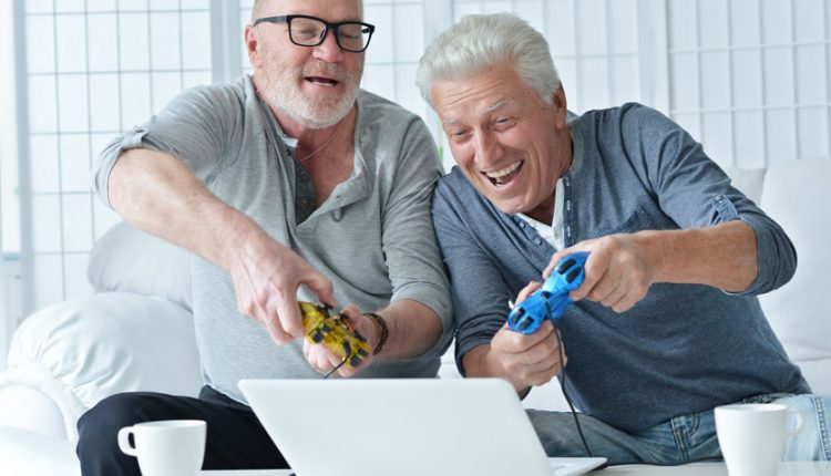 two senior men happily playing a video game