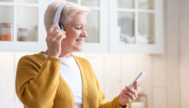 Smiling mature woman listening to songs with headphones