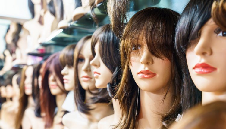 Different types of wigs on mannequin heads in a shop