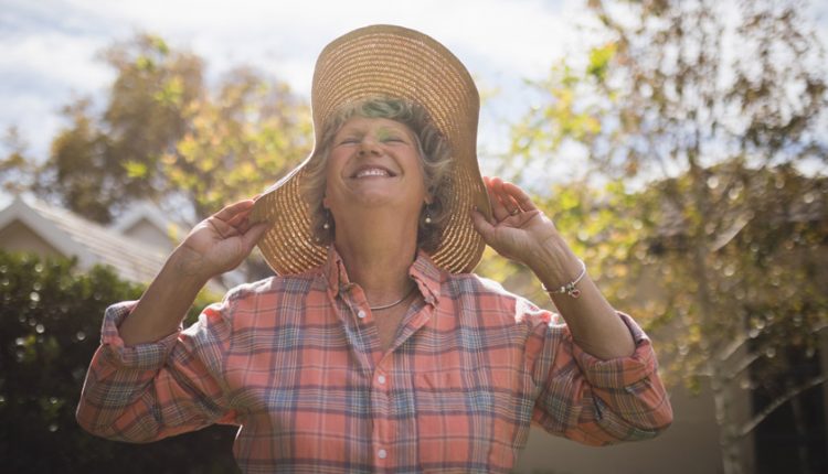 Senior woman wearing a summer hat in the sunlight