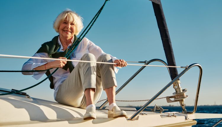 Happy senior woman enjoying a sea trip alone