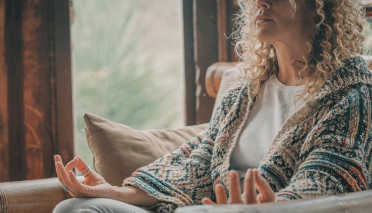 A woman sitting in an armchair doing yoga