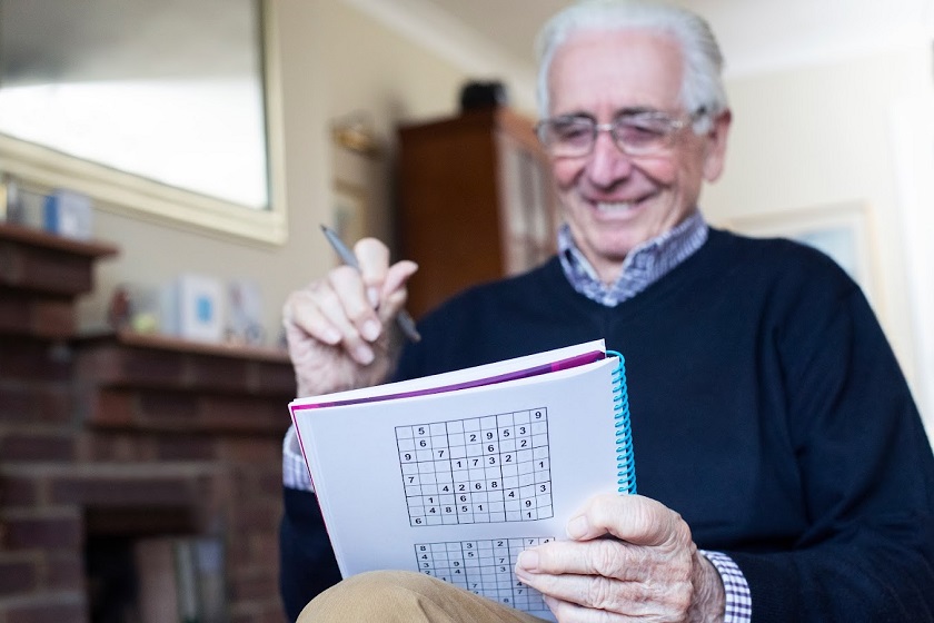 Senior Man Doing Sudoku Puzzle At Home